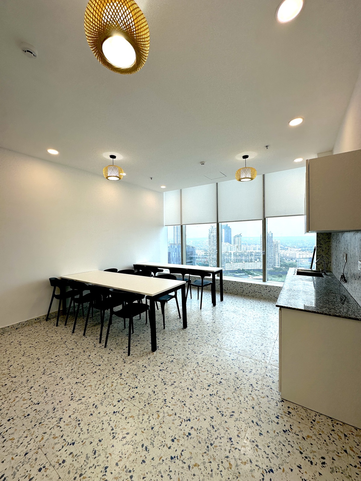 Qaarya canteen and pantry with dining tables and Gurugram skyline view