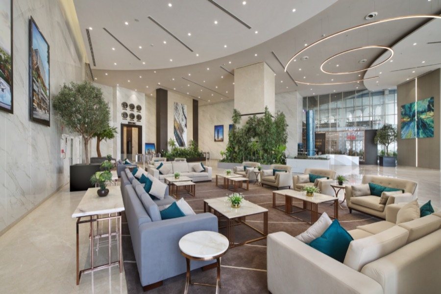 Lobby lounge at M3M IFC in Gurugram with seating, indoor plants and a curved ceiling
