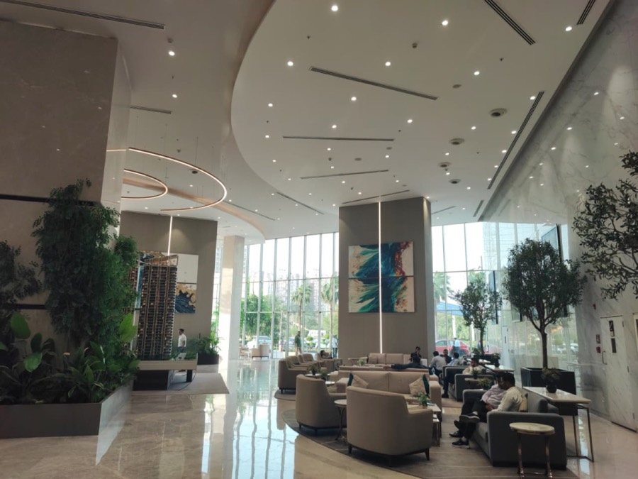Spacious M3M IFC lobby seating area with plants and floor-to-ceiling windows